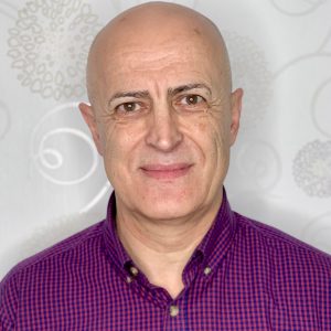 Tihomi smiling in front of a white patterned wall