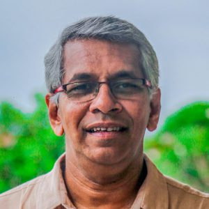 Dharshan smiling with the treetops in the horizon