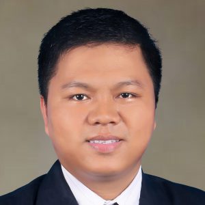 Peter Mang smiling in a suit and tie