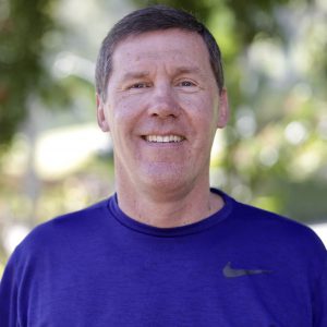 Jeff smiling outside in a blue shirt