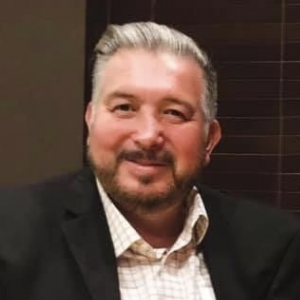 Dr. Espejel smiling in a dress shirt and jacket